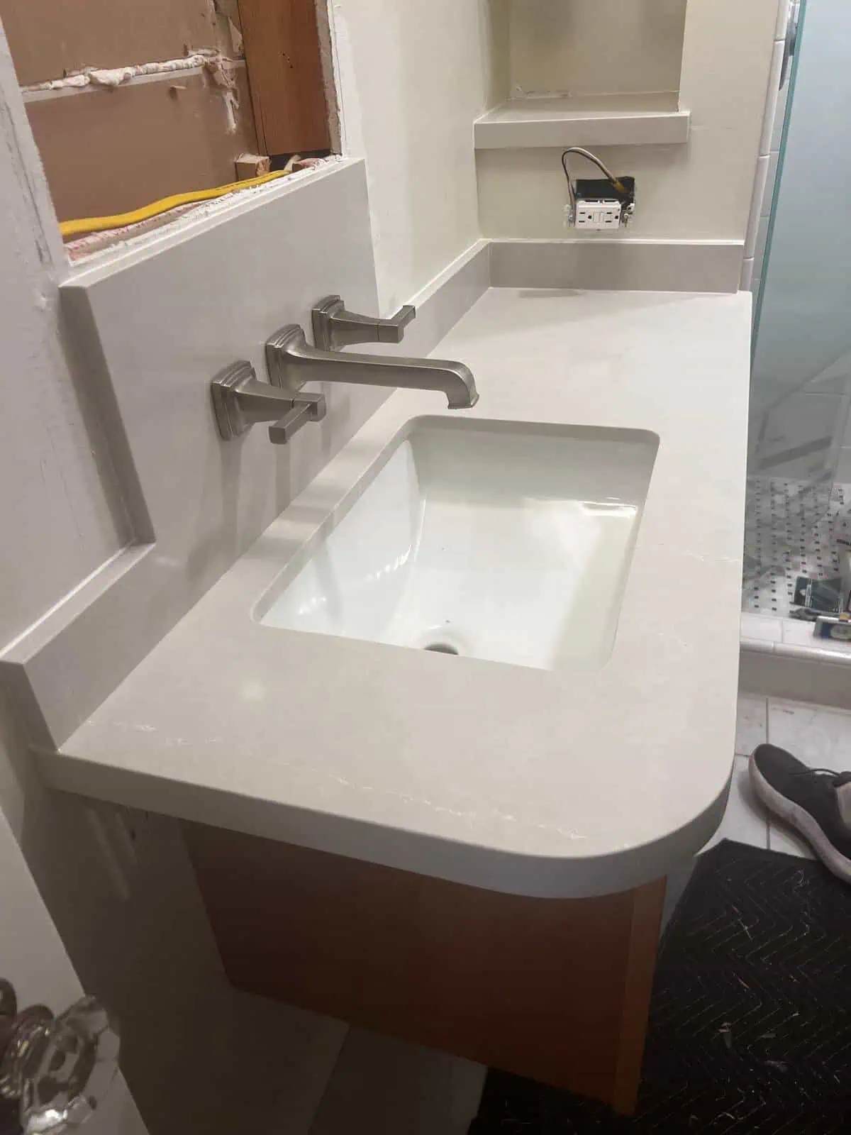 Contemporary bathroom vanity with integrated sink and wall-mounted faucets.