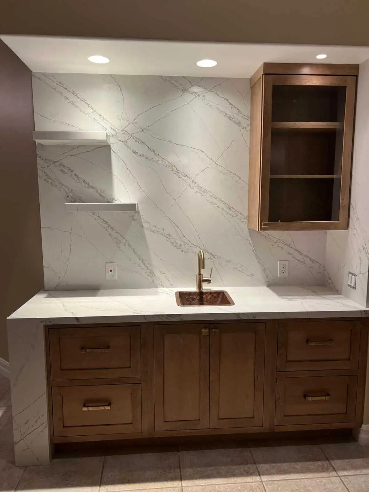 Modern kitchen with marble backsplash and wooden cabinetry.
