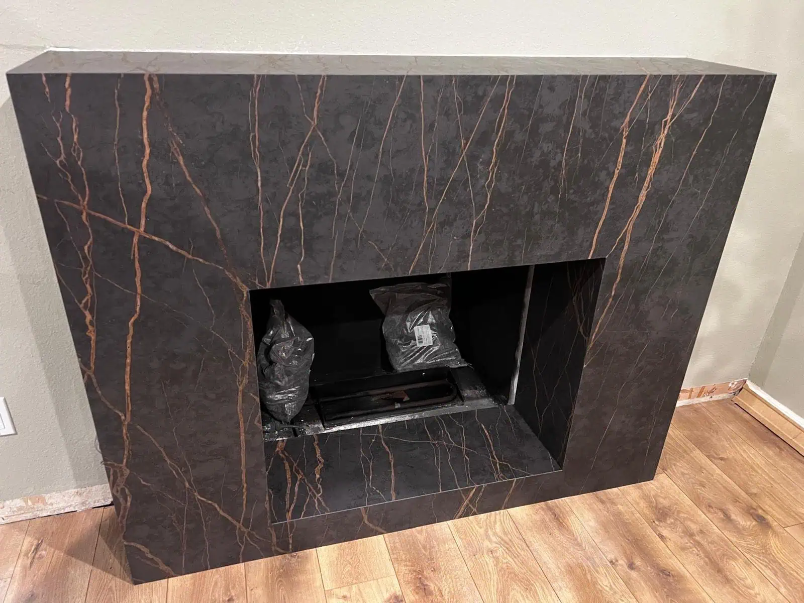 Luxury black marble fireplace with gold veining for modern interiors.
